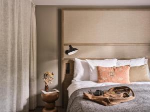 a bedroom with a bed with a large headboard at Nomad by CERVO Mountain Resort in Zermatt