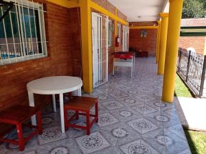 a porch with a table and chairs and a floor at LOS BULGAROS in Villa Cura Brochero