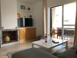 a living room with a couch and a table and a tv at Casa con Tranquilidad in El Rompido