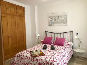 ein Schlafzimmer mit einem Bett mit lila Kissen in der Unterkunft Casa con Tranquilidad in El Rompido