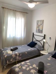 1 Schlafzimmer mit 2 Betten und einem Fenster in der Unterkunft Casa con Tranquilidad in El Rompido