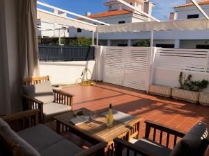 eine Terrasse mit einem Tisch und Stühlen auf dem Balkon in der Unterkunft Casa con Tranquilidad in El Rompido