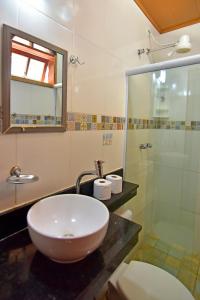 y baño con lavabo y ducha acristalada. en Estalagem 11 Suites, en Arraial do Cabo