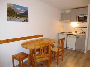 eine kleine Küche mit einem Holztisch und Stühlen in der Unterkunft Boost Your Immo Artigalas Barèges PM11 in Barèges