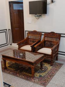 two chairs and a coffee table in a living room at Hotel MSD Niwas in Mandāwa