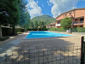 uma piscina numa villa com uma montanha ao fundo em House in a beautiful residence with garden, swimming pool and parking spot - Larihome A07 em Domaso