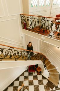 Eine Frau, die unten an einer Wendeltreppe steht. in der Unterkunft Plaza Central in Arequipa