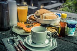 uma mesa coberta com pratos de comida e uma chávena de café em Art BBQ Lodge em Campos do Jordão