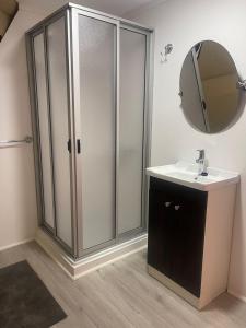 a bathroom with a shower and a sink and a mirror at El Bosque Lodge in Algarrobo