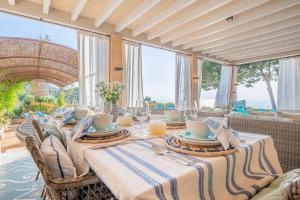 a dining room with a table and chairs and windows at Villa Rafam - Deia in Deia