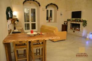 ein Wohnzimmer mit einem Tisch und einem Kamin in der Unterkunft Casa Vacanza La Cava nel Barisano Suite Matera in Matera