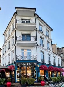 un grand bâtiment blanc avec une façade de magasin dans l'établissement Amo's Hotel, à Shkodër