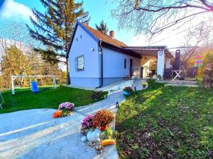 a small white house with flowers on the driveway at Casa Quattro stagioni Fruska gora in Čerević