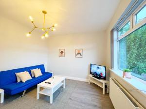 a living room with a blue couch and a tv at Cheerful 3 bedroom home with Netflix and Wi-Fi in Middleton