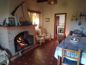 a living room with a brick fireplace with a table and a table at Finca El Palomar in Fuenteheridos