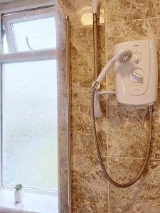 y baño con ducha con cabezal de ducha. en Cheerful 3 bedroom home with Netflix and Wi-Fi, en Middleton