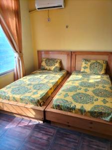 two beds sitting next to each other in a room at Hotel Karma Muzaffarabad in Muzaffarabad