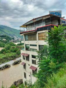 穆札法拉巴德的住宿－Hotel Karma Muzaffarabad，河边的山丘上的建筑