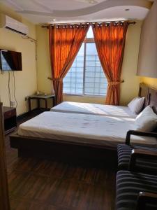 a bedroom with a large bed and a window at Hotel Karma Muzaffarabad in Muzaffarabad
