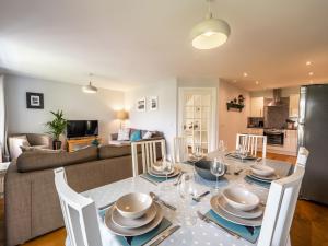 a dining room and living room with a table and chairs at The Cottage at Corriness House in Achnasheen