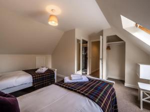 una camera con due letti e un tavolo di The Cottage at Corriness House ad Achnasheen