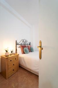 een slaapkamer met een bed en een houten dressoir naast een deur bij La Ruteña in Rute