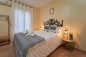 een slaapkamer met een groot wit bed en een raam bij La Ruteña in Rute