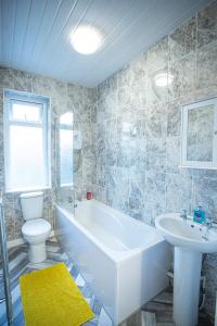 a bathroom with a tub and a toilet and a sink at Cheerful 3 bedroom home with Netflix and Wi-Fi in Middleton