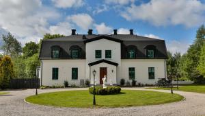 ein großes weißes Haus mit schwarzem Dach in der Unterkunft Disponentvillan Lilla Edet / Göta in Lilla Edet