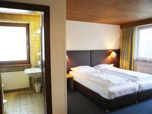 Habitación de hotel con cama y lavabo en Gasthof Pension Madseiterhof, en Tux
