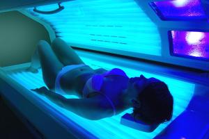una mujer tendida en una piscina con luces azules en Landhotel Ridder, en Bad Laer