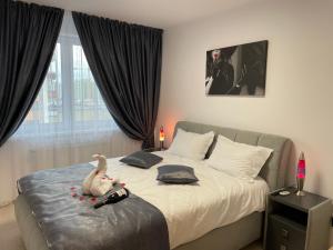 a bedroom with a bed with a stuffed duck on it at Apartamente Lux SYA Residence in Braşov
