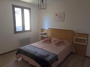 ein Schlafzimmer mit einem Bett mit zwei Kissen darauf in der Unterkunft Les rives du Drac in Chabottes