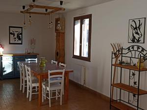 eine Küche und ein Esszimmer mit einem Holztisch und Stühlen in der Unterkunft Les rives du Drac in Chabottes