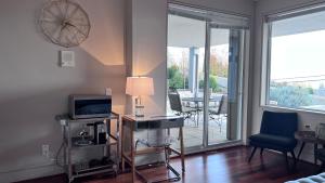un soggiorno con TV e tavolo con lampada di Kia Oceanview Property a West Vancouver
