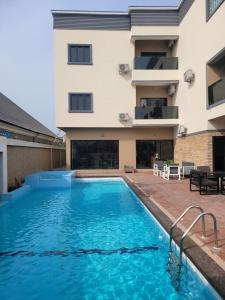 einem Pool vor einem Gebäude in der Unterkunft The Charis Hotel & Suites in Port Harcourt