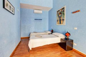 ローマにあるRoman Houseの青い壁のベッドルーム1室、ベッド1台、テーブルが備わります。