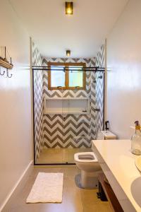 uma casa de banho com um chuveiro, um WC e um lavatório. em Casa Kai 