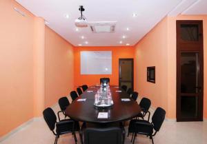 une salle de conférence avec une grande table et des chaises dans l'établissement Perla Hôtel, à Fès