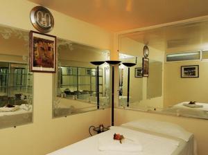 ein Schlafzimmer mit einem Bett und einem großen Spiegel in der Unterkunft Perla Hôtel in Fès