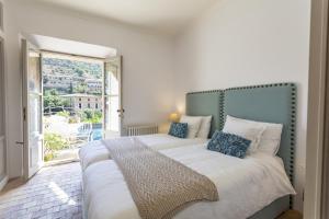 a bedroom with a large bed and a large window at Casa Berne - Deia in Deia