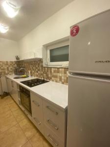 a kitchen with a refrigerator and a stove top oven at Vila E&E in Mavrovo