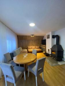 a living room with a table and chairs and a stove at Vila E&E in Mavrovo