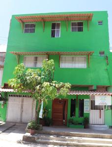 een groen gebouw met een boom ervoor bij Suítes Mar de Maragogi in Maragogi