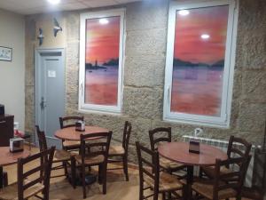 due tavoli in un ristorante con due finestre di Hotel Náutico a Vigo