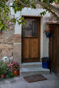 una puerta de madera de una casa con macetas de flores en CASA PARAFITA en Rosal