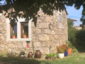 un edificio de piedra con macetas delante de una ventana en CASA PARAFITA en Rosal