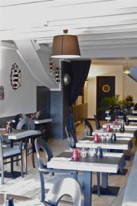 a row of tables and chairs in a restaurant at Hôtel De Paris in Barneville-Carteret
