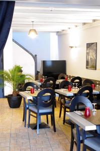 a restaurant with tables and chairs in a room at Hôtel De Paris in Barneville-Carteret