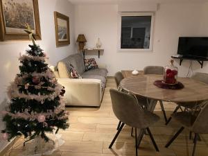 un salon avec un arbre de Noël et une table dans l'établissement Les écureuils, à Xonrupt-Longemer